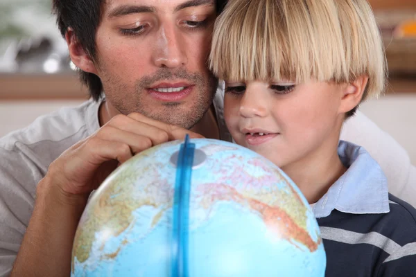 Pai e filho olhando para o globo — Fotografia de Stock