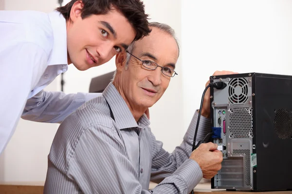 Pai e filho consertando um computador — Fotografia de Stock