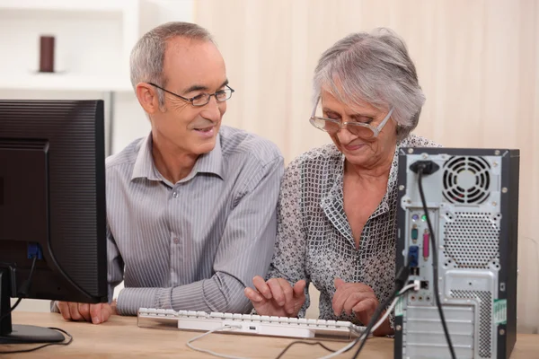Веселая пожилая пара просматривает в Интернете — стоковое фото