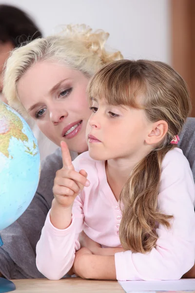 Moeder en dochter kijken naar een licht globe — Stockfoto