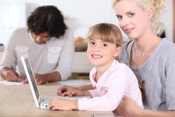 Девушка с ноутбуком с родителями — стоковое фото