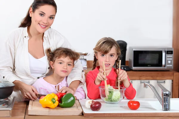 Mother and daughters preparing salad — Stock Photo, Image