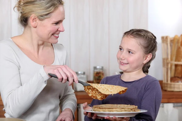 Bir anne kızıyla birlikte krep pişirme. — Stok fotoğraf