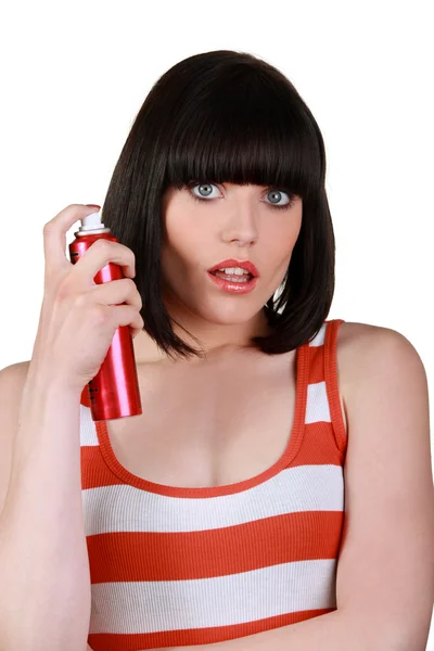 Ung kvinna med en burk hårspray — Stockfoto