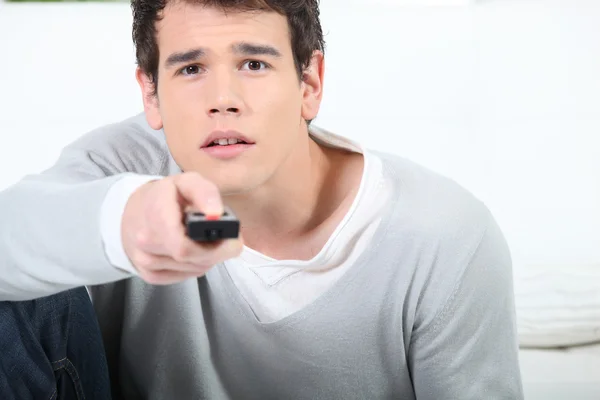 Jeune homme utilisant une télécommande — Photo