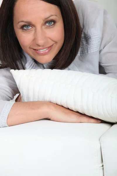 ソファの上に置かれる茶色の髪の女性 — ストック写真