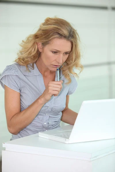 Blond kvinna stod arbetar på bärbar dator — Stockfoto