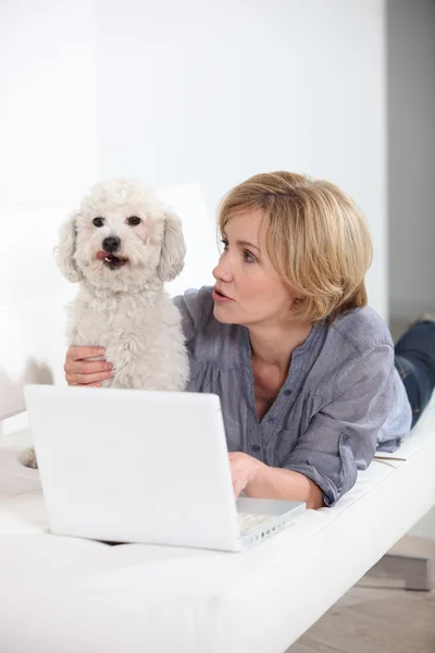 Γυναίκα με φορητό υπολογιστή και σκύλου — Φωτογραφία Αρχείου