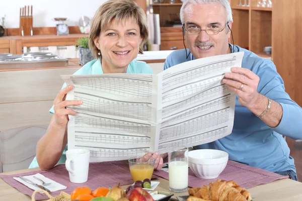 Seniorenpaar liest Zeitung — Stockfoto