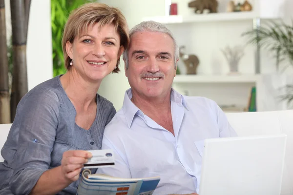 Vzorný manželský pár všechny usmívá s počítačem sdílení okamžiku — Stock fotografie