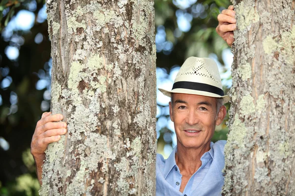 Alter Mann stand zwischen zwei Bäumen — Stockfoto