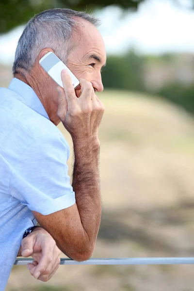 Ηλικιωμένος άνδρας, μιλάμε για το κινητό τηλέφωνο σε εξωτερικούς χώρους — Φωτογραφία Αρχείου
