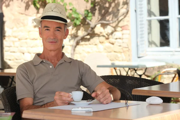 Uomo anziano che si gode una tazza di caffè in un caffè — Foto Stock