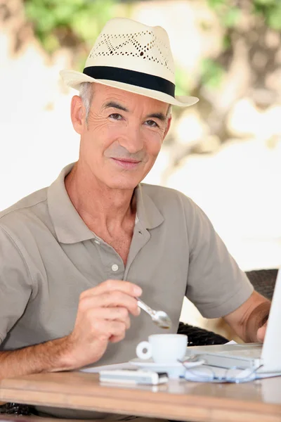 Homme plus âgé dehors avec un ordinateur portable et un expresso — Photo