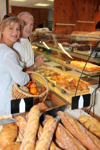 Mature couple in a bakery — Stock Photo, Image