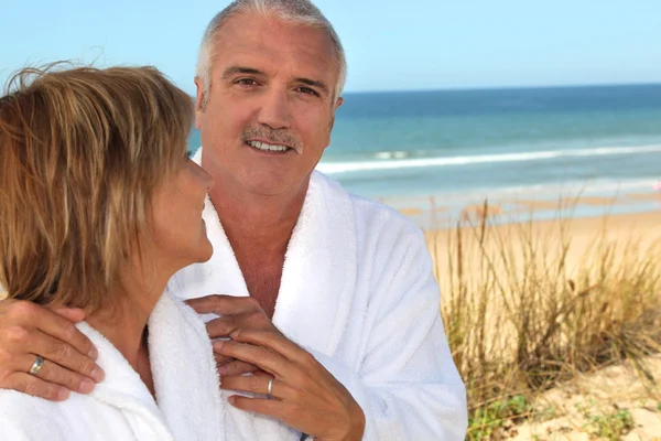 Mogen kvinna stirrar kärleksfullt på sin partner i sanddynerna — Stockfoto