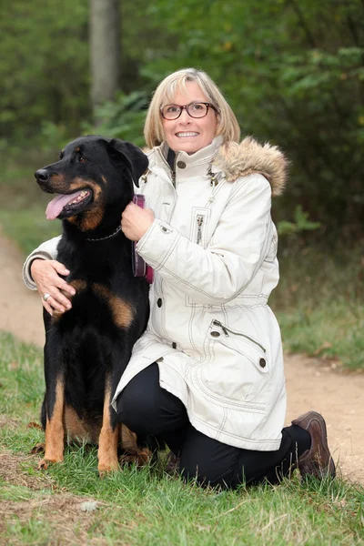 Donna che porta a spasso il cane in campagna — Foto Stock