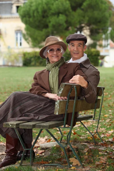 Yaşlı çift bankta oturdu — Stok fotoğraf
