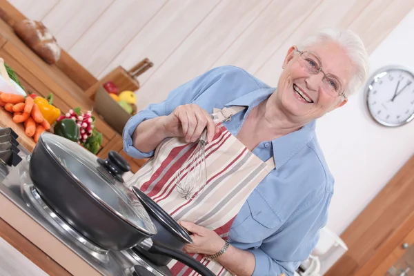 Stará dáma vaření v kuchyni — Stock fotografie