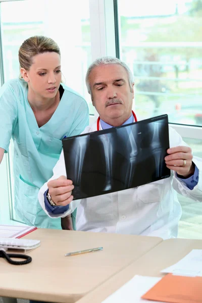 Doutor e enfermeira examinando um raio-x — Fotografia de Stock
