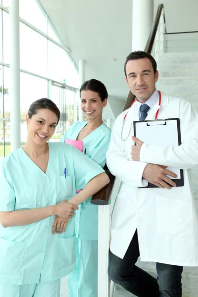 Doutor e duas enfermeiras em pé em uma escada em um hospital — Fotografia de Stock