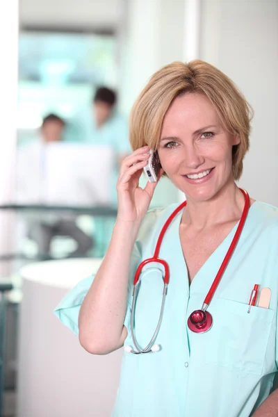 Medic med stetoskop och mobiltelefon — Stockfoto