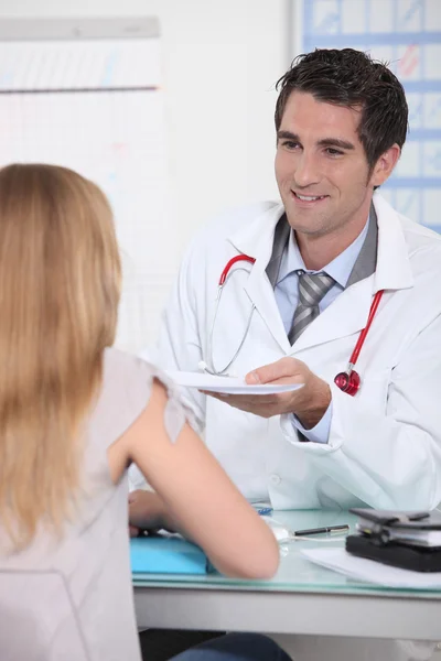Doctor handing a prescription to a female patient — Stock Photo, Image