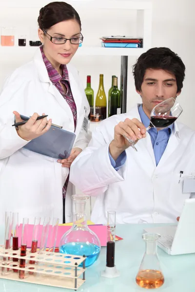 Два учёных с вином в лаборатории — стоковое фото