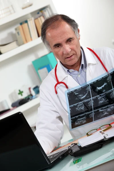 Доктор смотрит на сканирование — стоковое фото