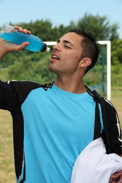 Voetballer drinken energiedrank — Stockfoto
