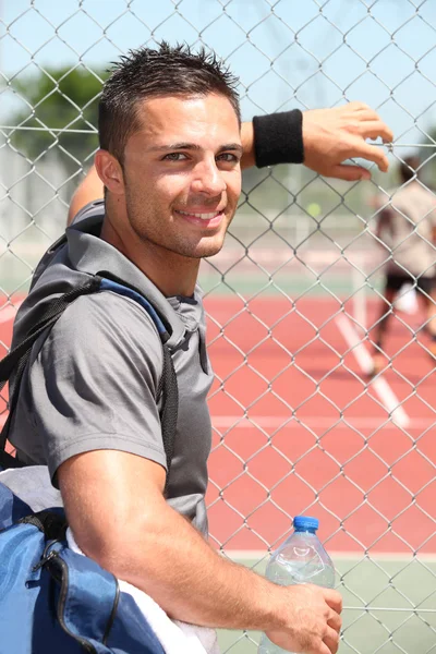 Joven jugador de tenis viendo un juego — Foto de Stock