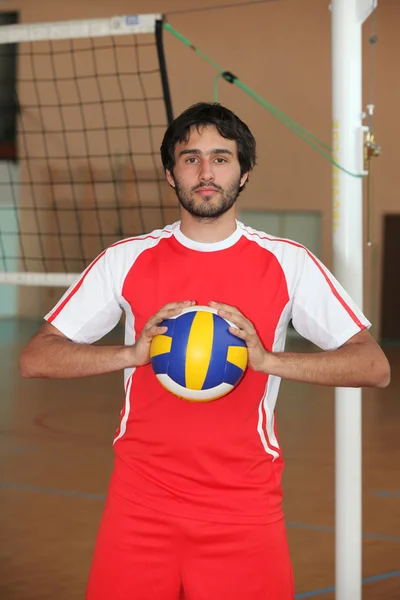 Volleyball player with ball in front of net — Stock Photo, Image
