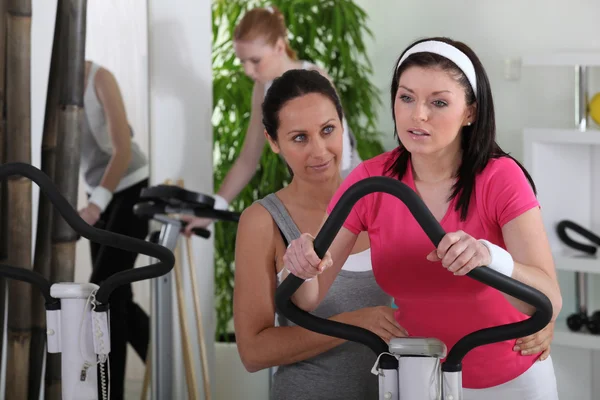 女性骑一辆自行车在健身房 — 图库照片