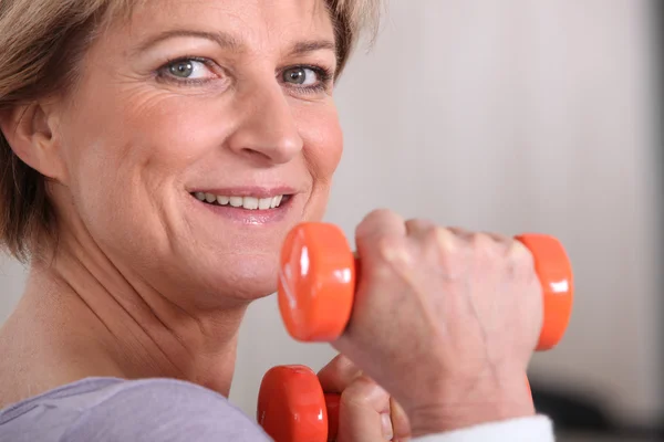 Frau hebt Hanteln im Fitnessstudio — Stockfoto