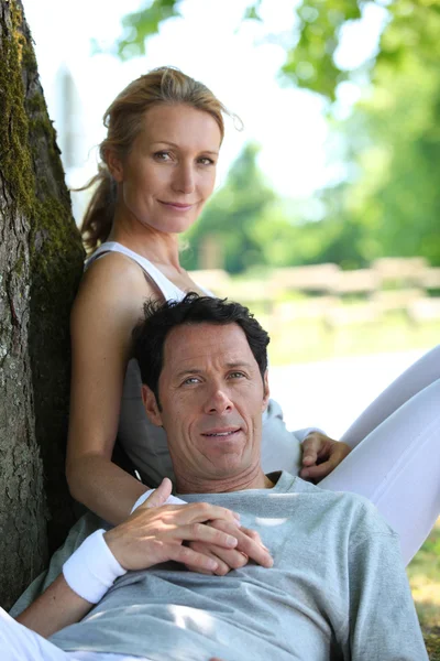 Fit athletic couple relaxing in the park — Stock Photo, Image
