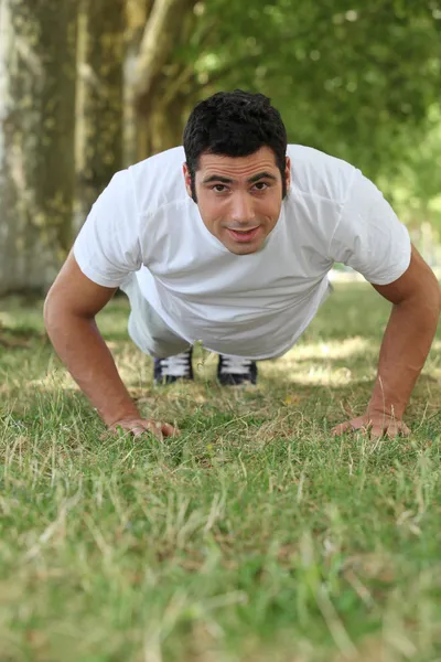 Ember csinál fekvőtámaszokat a parkban — Stock Fotó