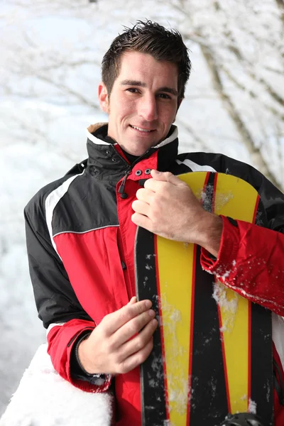 Hombre sosteniendo su tabla de snowboard — Foto de Stock