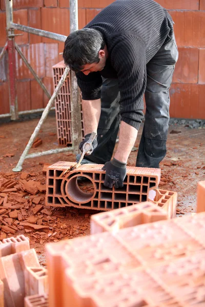 Workman sculpting a brick — Stock Photo, Image