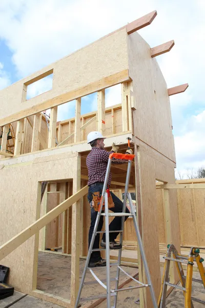 Trabalhador da construção civil construindo uma casa — Fotografia de Stock