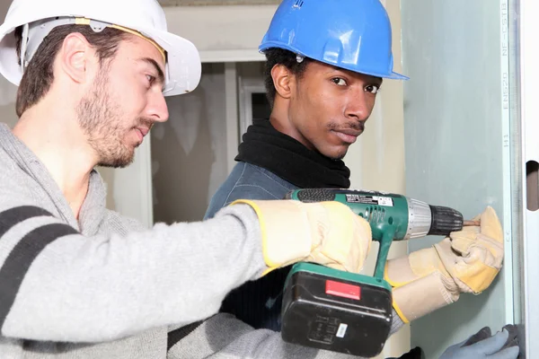 Men drilling into dry-wall — Stock Photo, Image