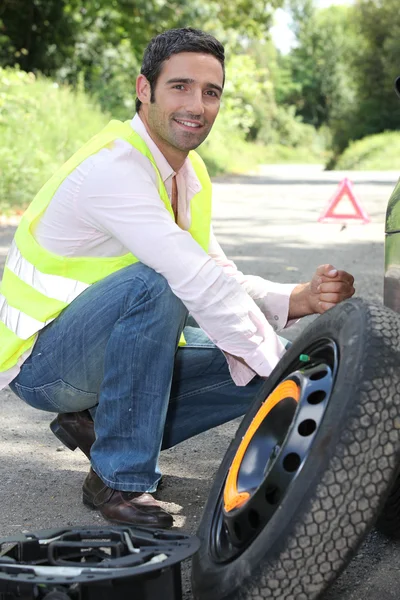 stock image Man changing a wheel