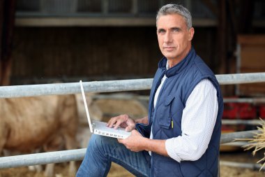 Farmer working on his laptop clipart
