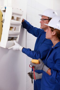 Electrical team installing a fusebox clipart