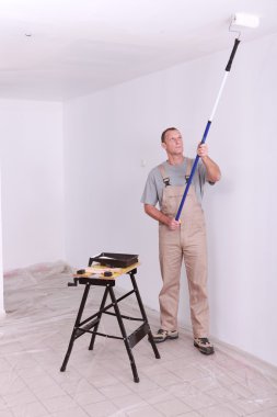 Man painting a room white clipart