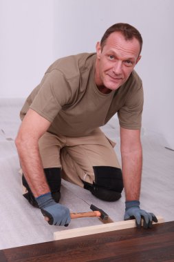 Man fitting laminate flooring clipart