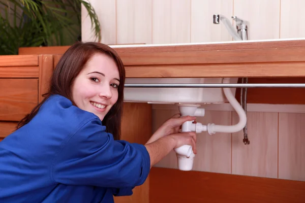 Young woman plumbing a sink — Stock Photo, Image