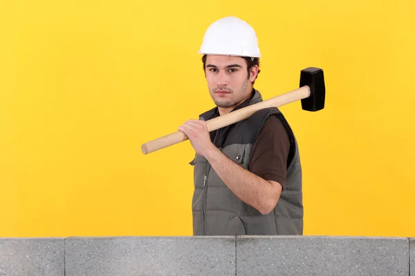 Obrero de la construcción sosteniendo un mazo — Foto de Stock
