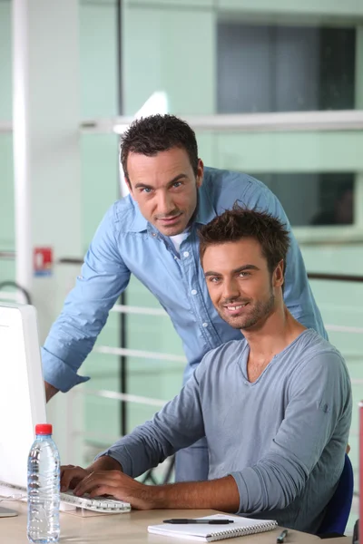 Två män arbetar på en stationär dator — Stockfoto