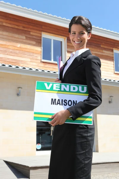 Estate agent with a vendu sign — Stock Photo, Image