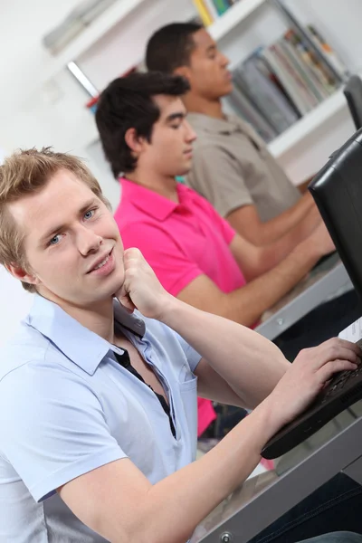Estudantes do sexo masculino em sala de aula trabalhando no laptop — Fotografia de Stock